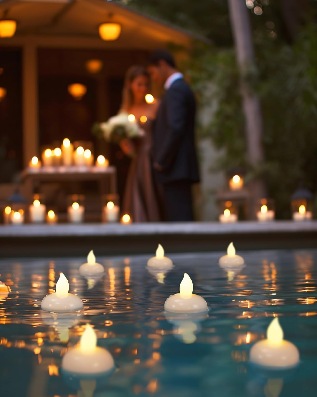Floating candles on a pool with a couple in the background