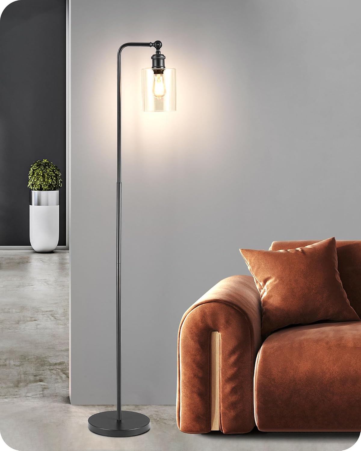 Floor lamp with a modern design next to a brown sofa in a room.