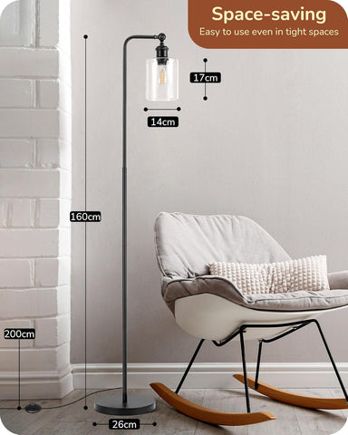 Floor lamp with measurements in a room setting, featuring a chair and white wall.