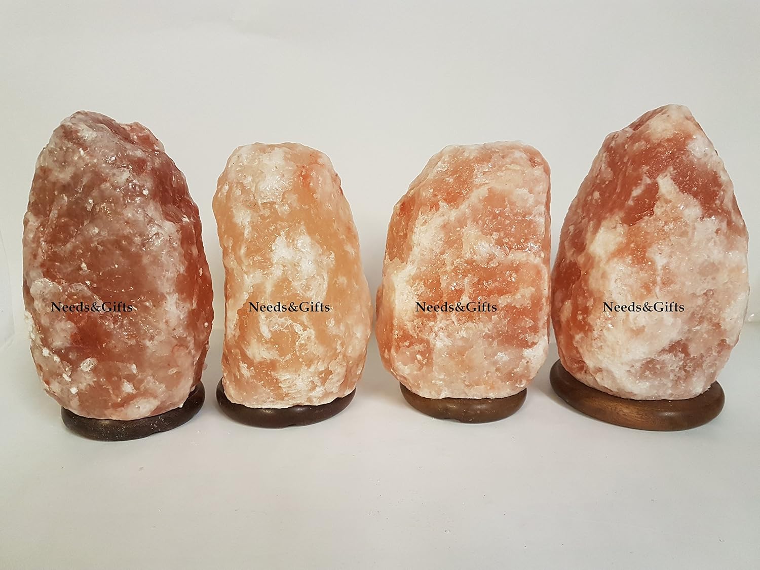 Four Himalayan salt lamps on a white background with 'Needs & Gifts' branding.