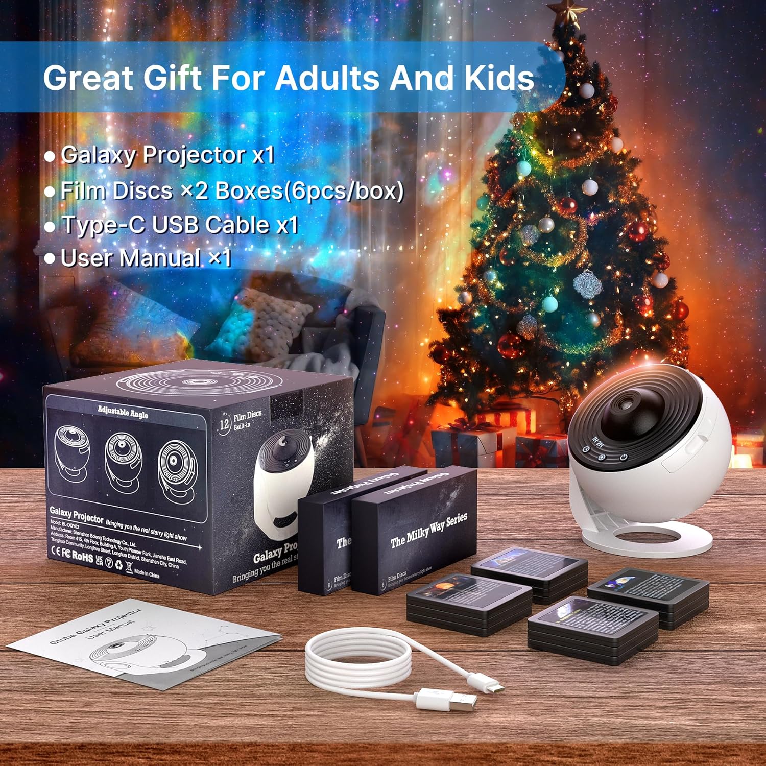 Galaxy projector set with discs and cable on a table in front of a decorated Christmas tree.