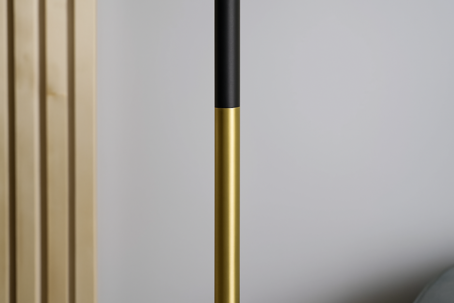 Gold and black cylindrical object against a neutral background