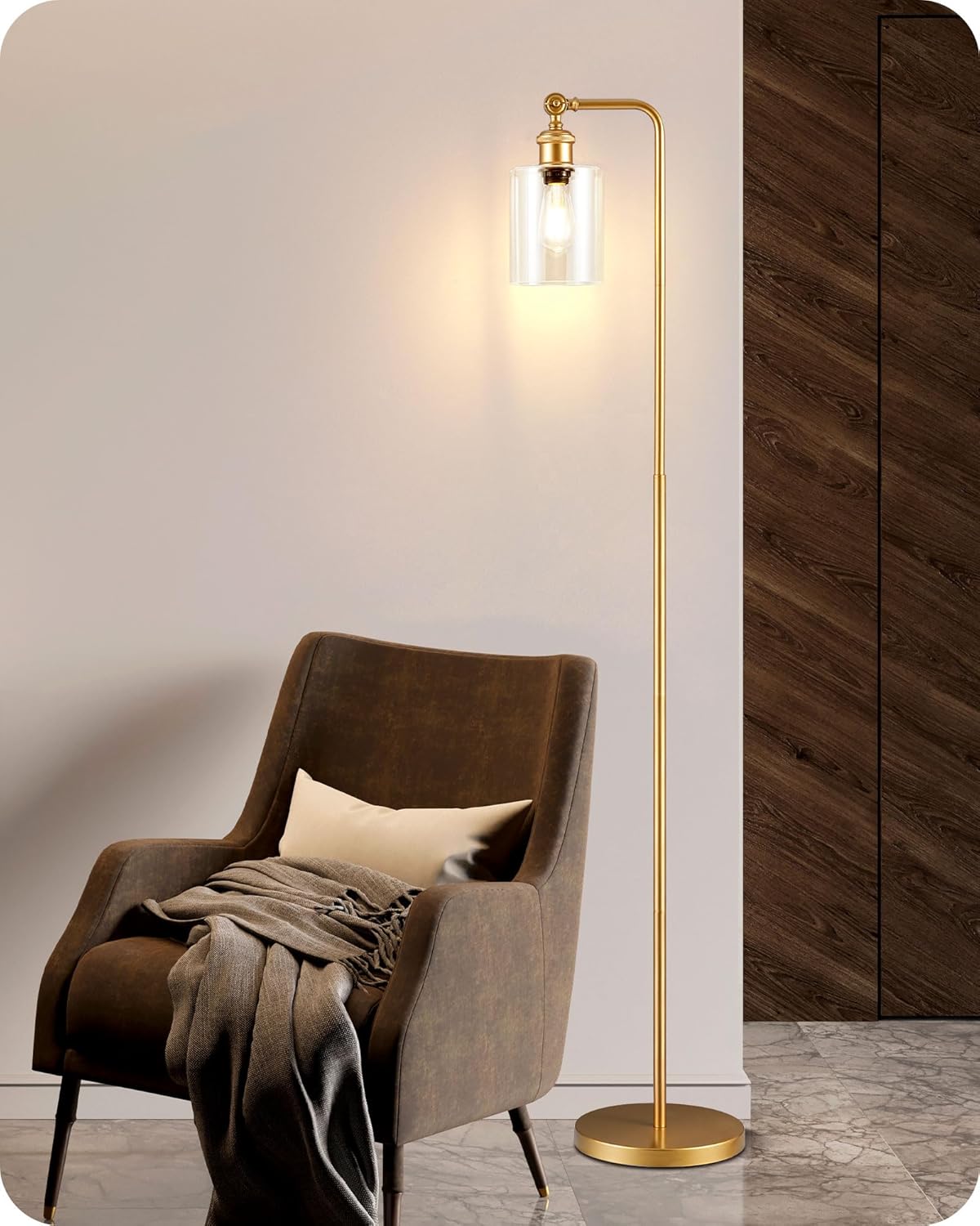 Gold floor lamp next to a brown armchair with a blanket in a room setting.