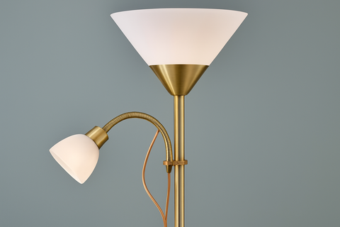 Gold floor lamp with a white shade on a gray background