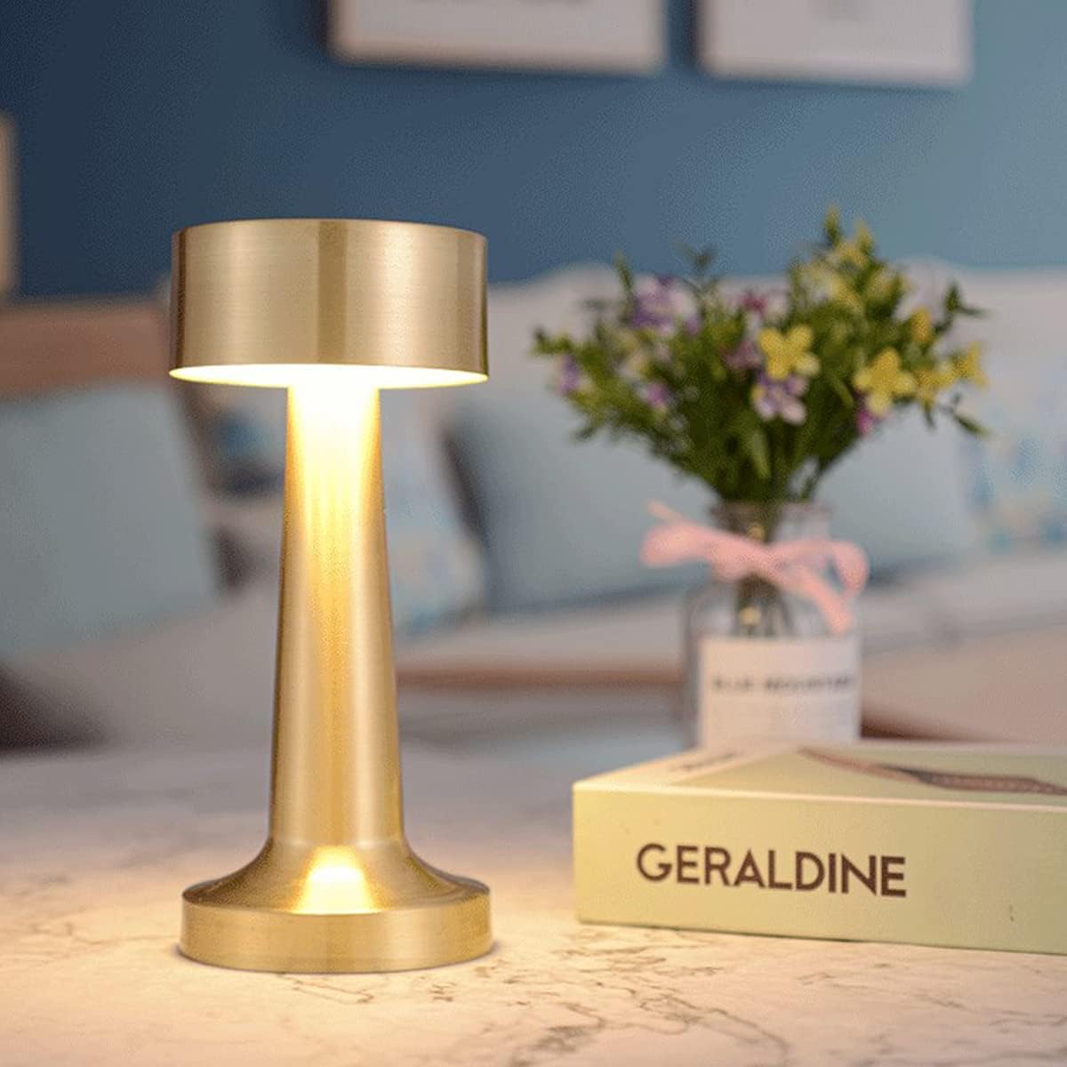 Gold table lamp on a surface with a blurred background of a room.