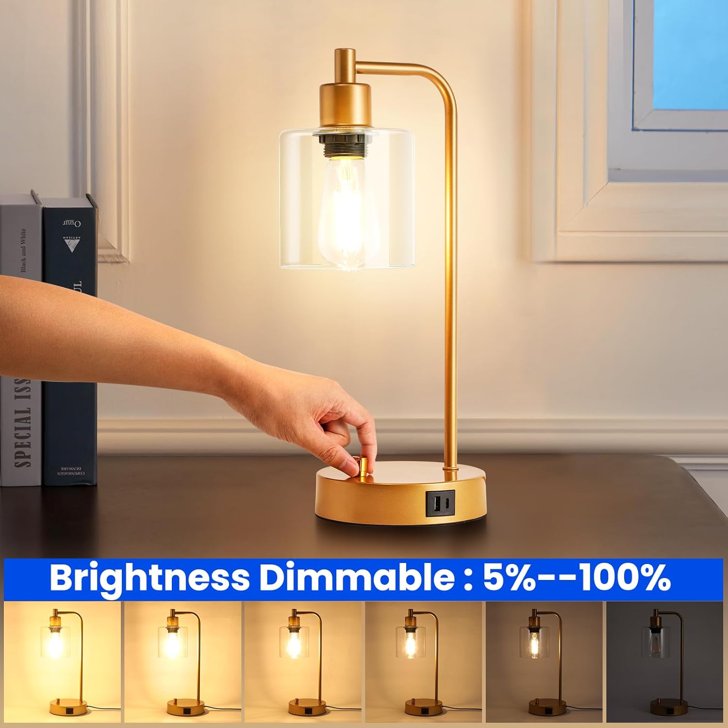 Gold table lamp with a hand adjusting the brightness, set against a neutral background.