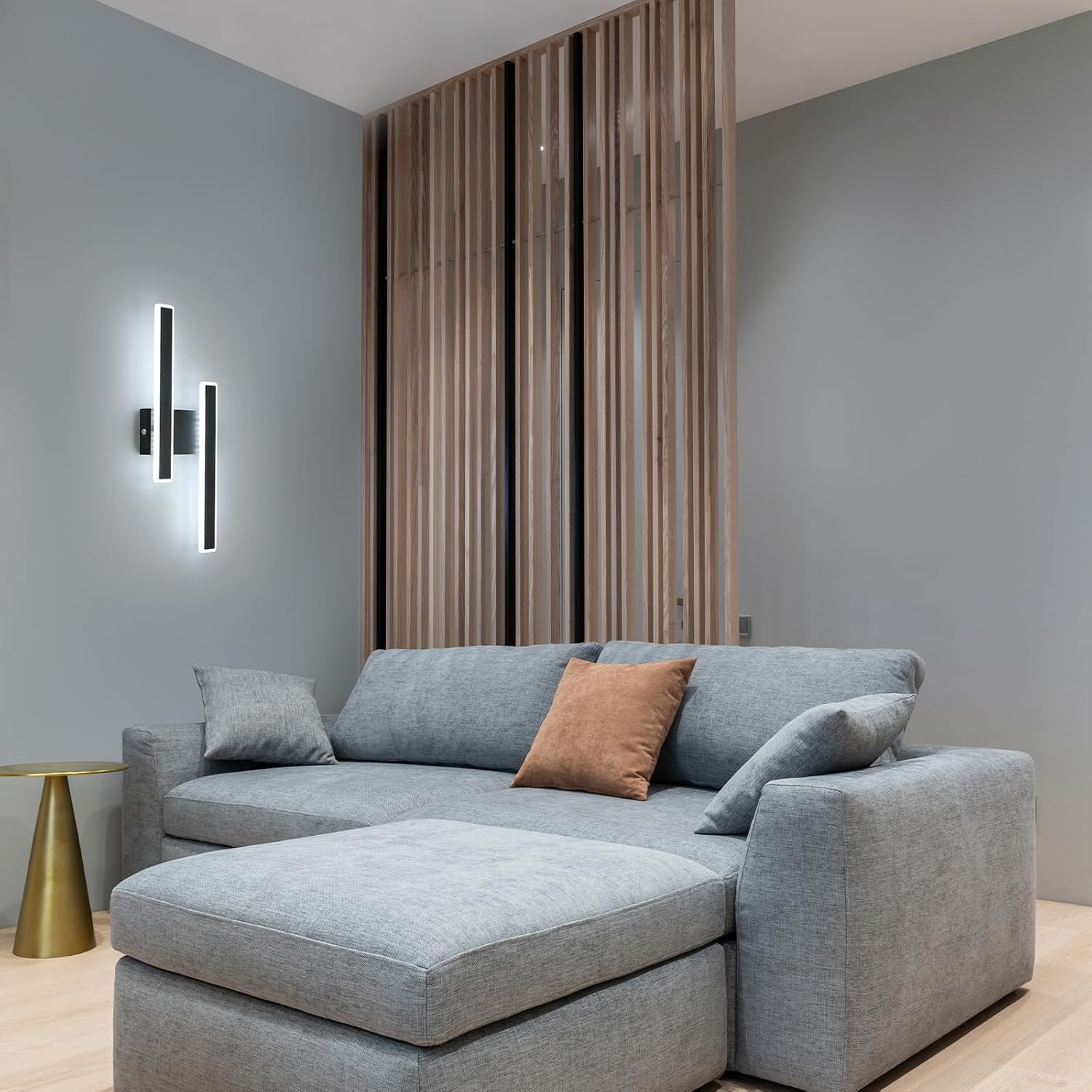 Gray sectional sofa with a brown pillow in a modern living room setting.