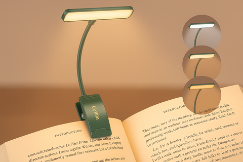 Green booklight on an open book with a warm glow