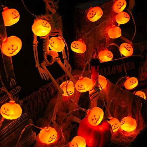 Halloween-themed string lights with jack-o'-lantern designs on a dark background.