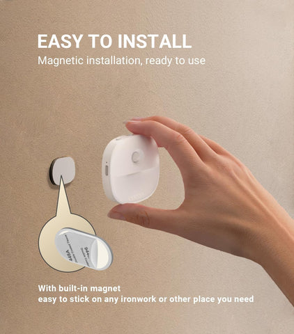 Hand holding a magnetic light fixture with text on an beige background