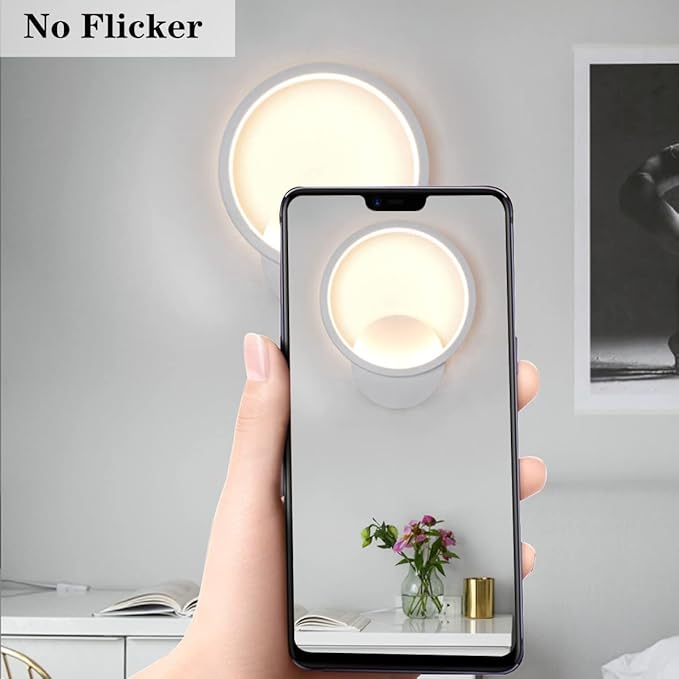 Hand holding a smartphone with a screen displaying a room view, showing a lamp and flowers.