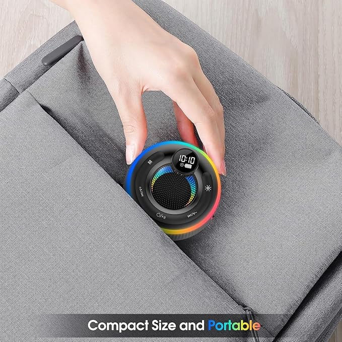 Hand placing a compact, portable device with a colorful design on a gray surface.