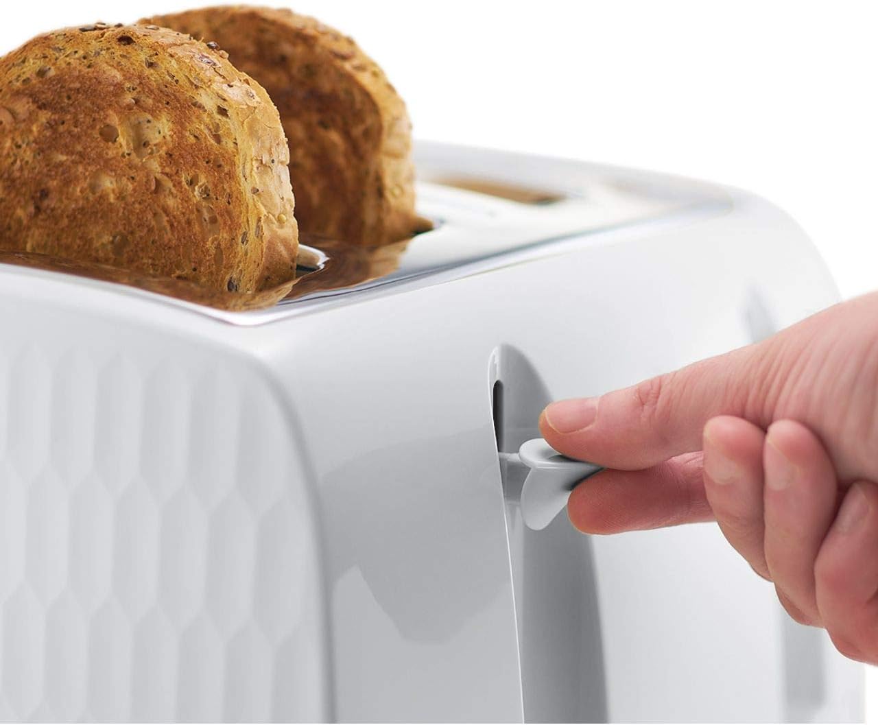 Hand pressing a button on a white toaster with two slices of bread inside.