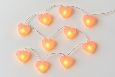 Heart-shaped string lights on a light gray background
