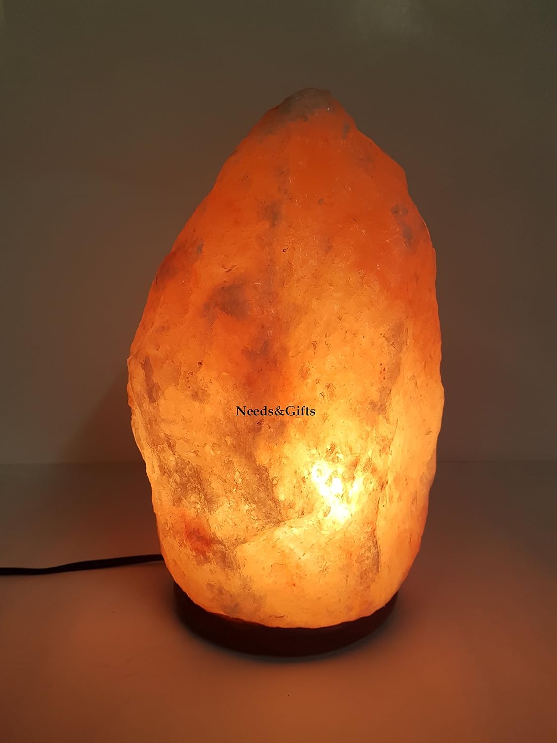 Himalayan salt lamp with a warm glow on a plain background