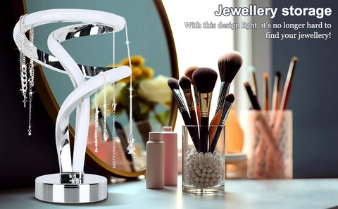 Jewellery storage solution with a spiral design on a table with makeup brushes and other items.