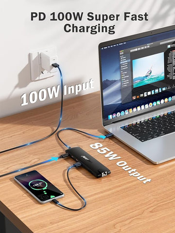 Laptop, smartphone, and power adapter on a desk with text indicating PD 100W super fast charging.