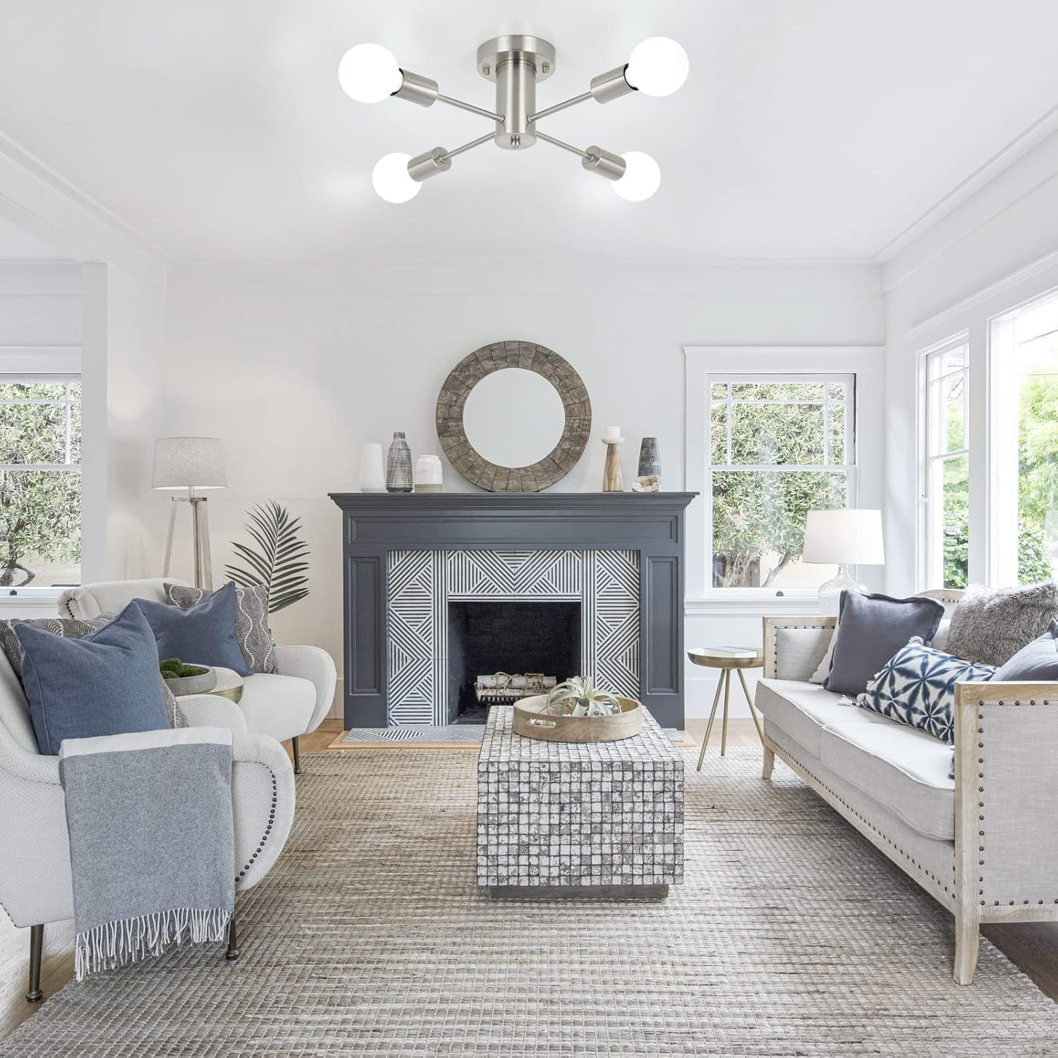 Living room with gray fireplace, white sofa, and modern ceiling light fixture.