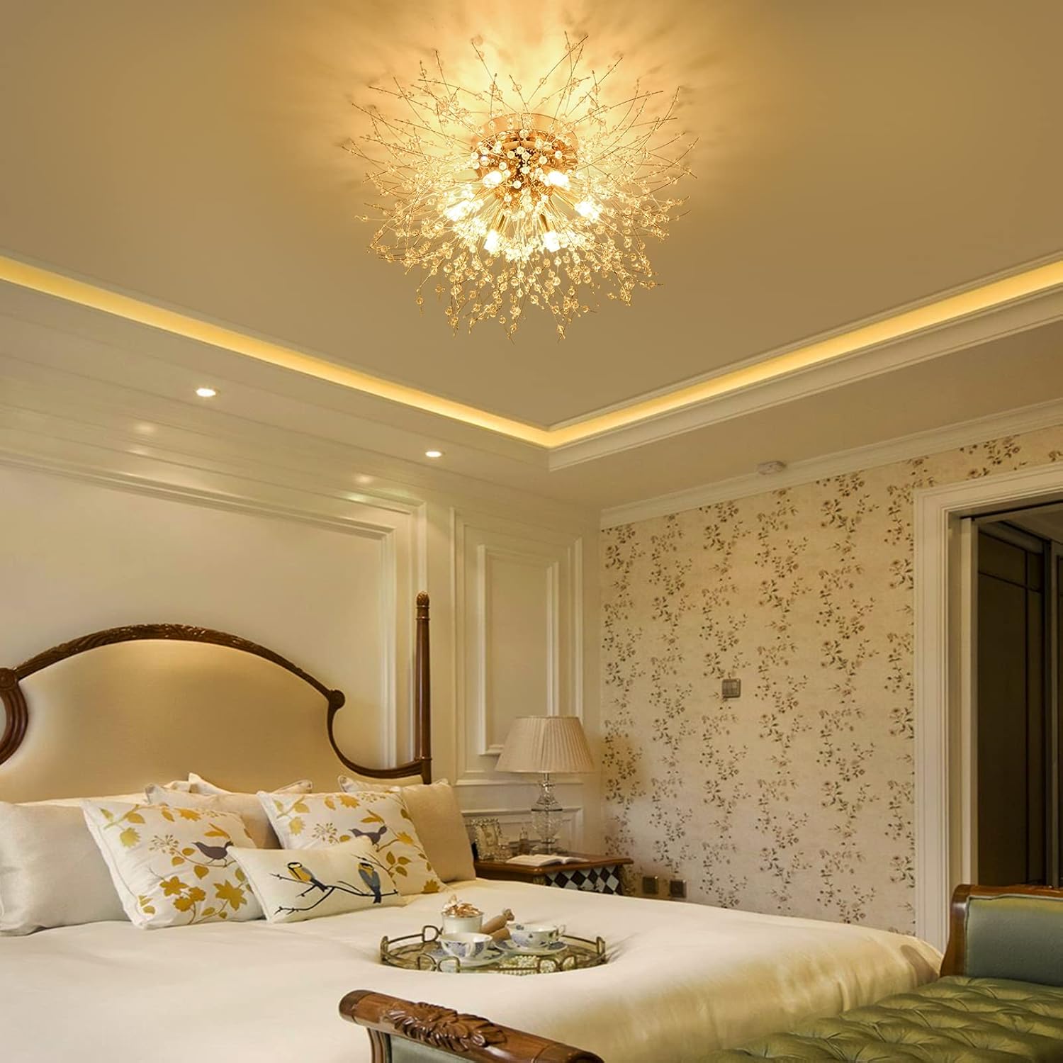 Luxurious bedroom with floral wallpaper, chandelier, and decorative pillows.