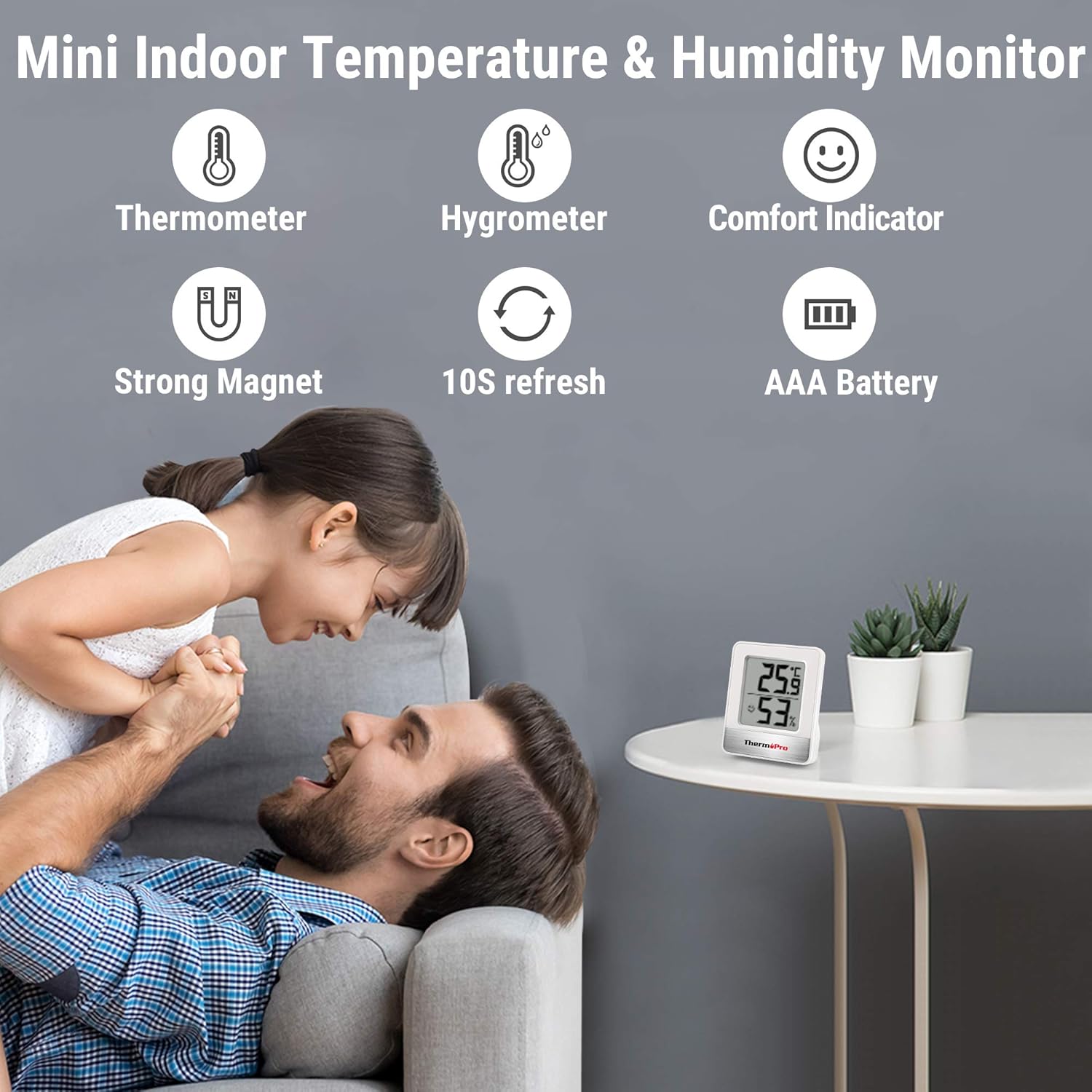 Mini indoor temperature and humidity monitor with family in the background