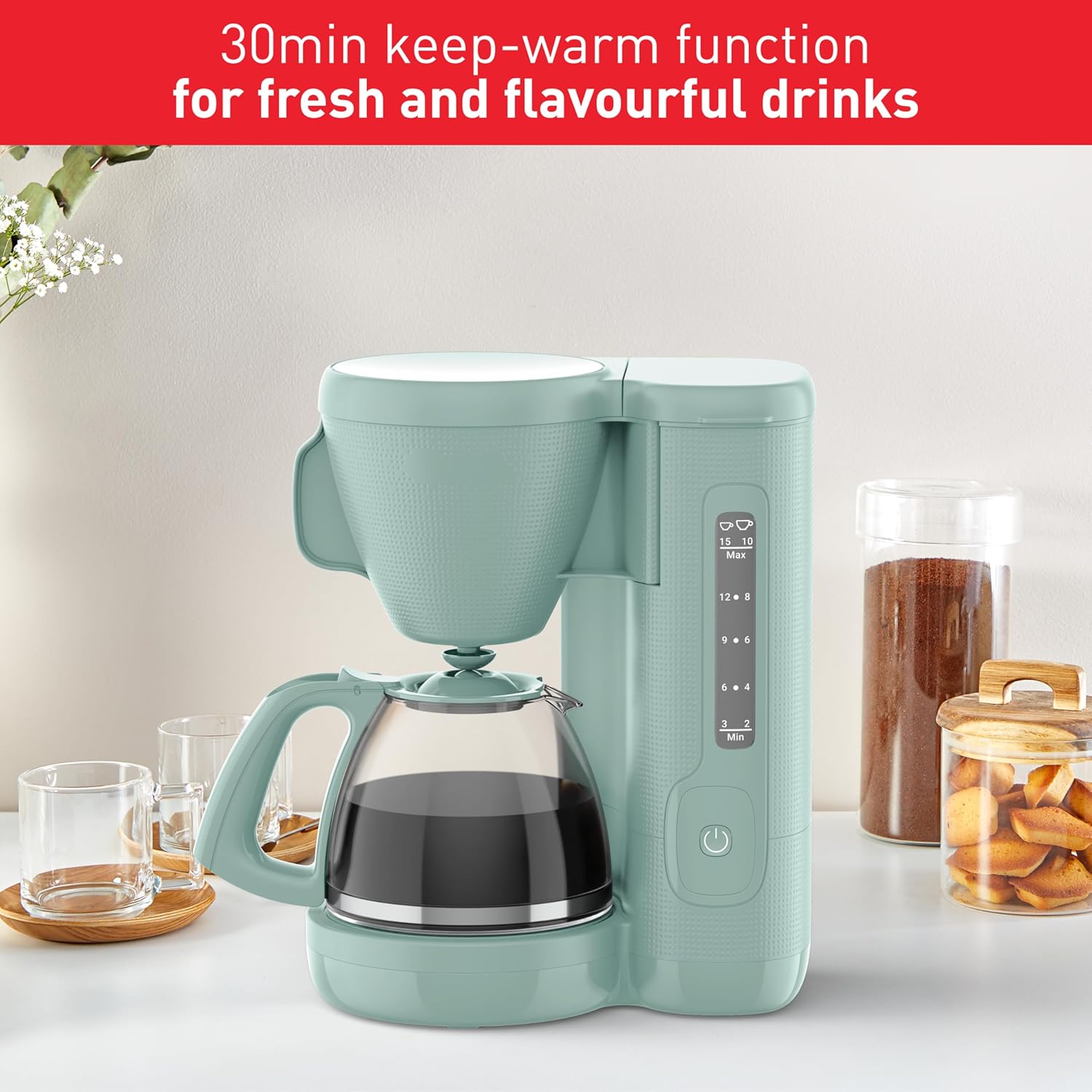 Mint green coffee maker on a kitchen counter with text about keep-warm function.
