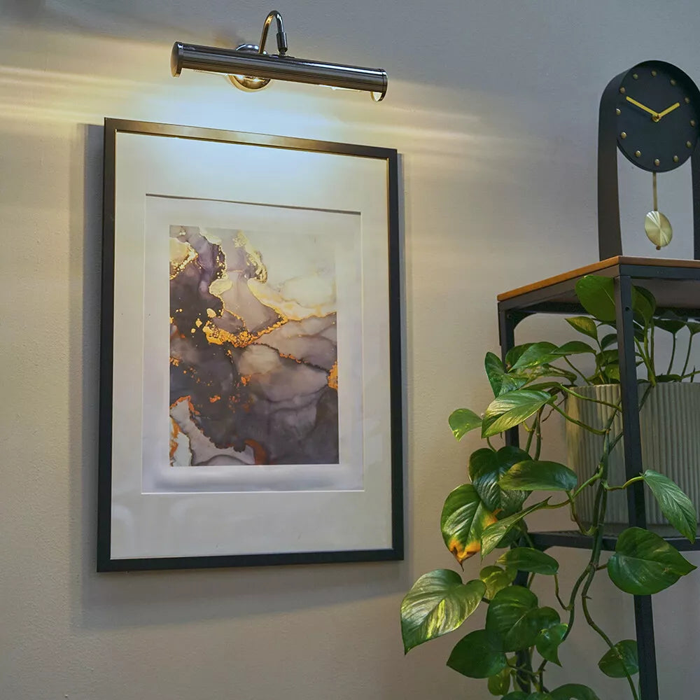 Satin nickel twin picture wall light highlighting framed photographs​