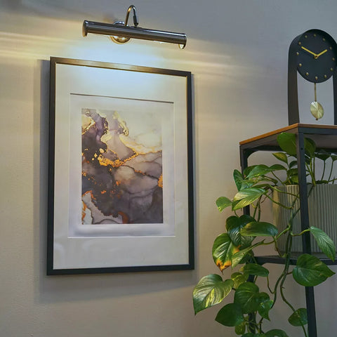 Satin nickel twin picture wall light highlighting framed photographs​