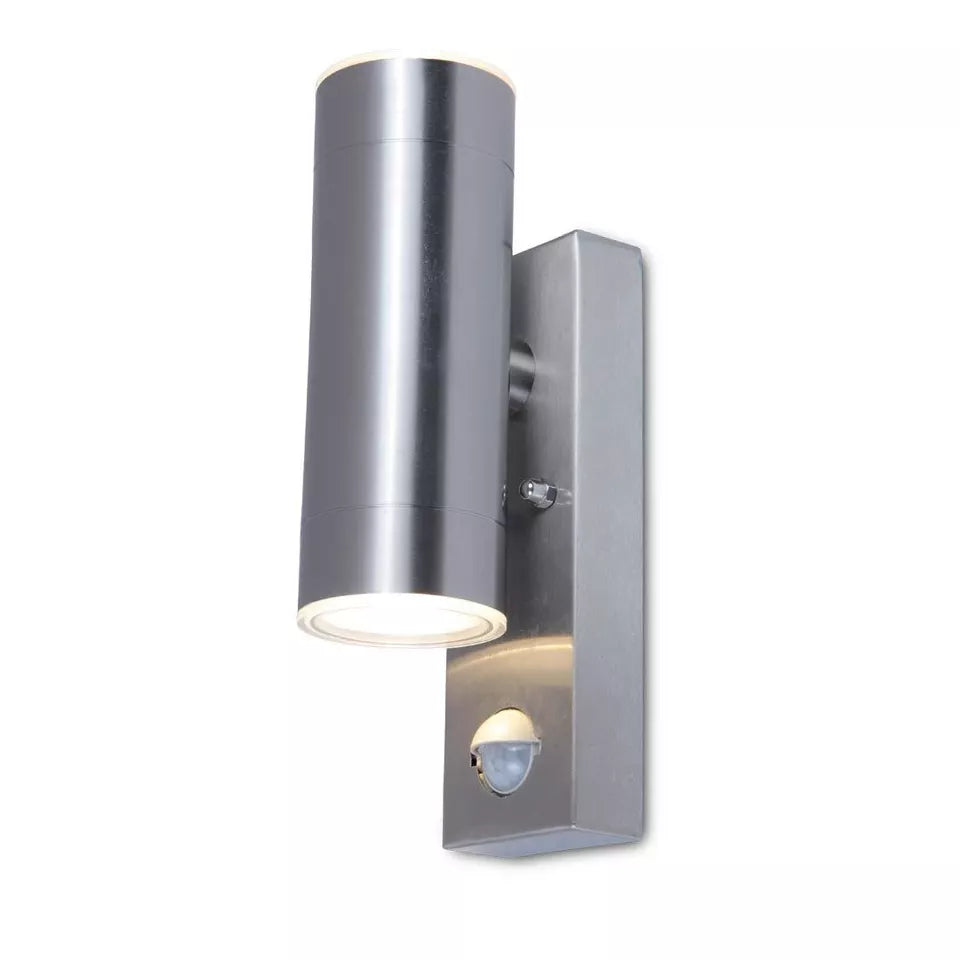 Stainless steel up down wall light providing illumination to a garden pathway

