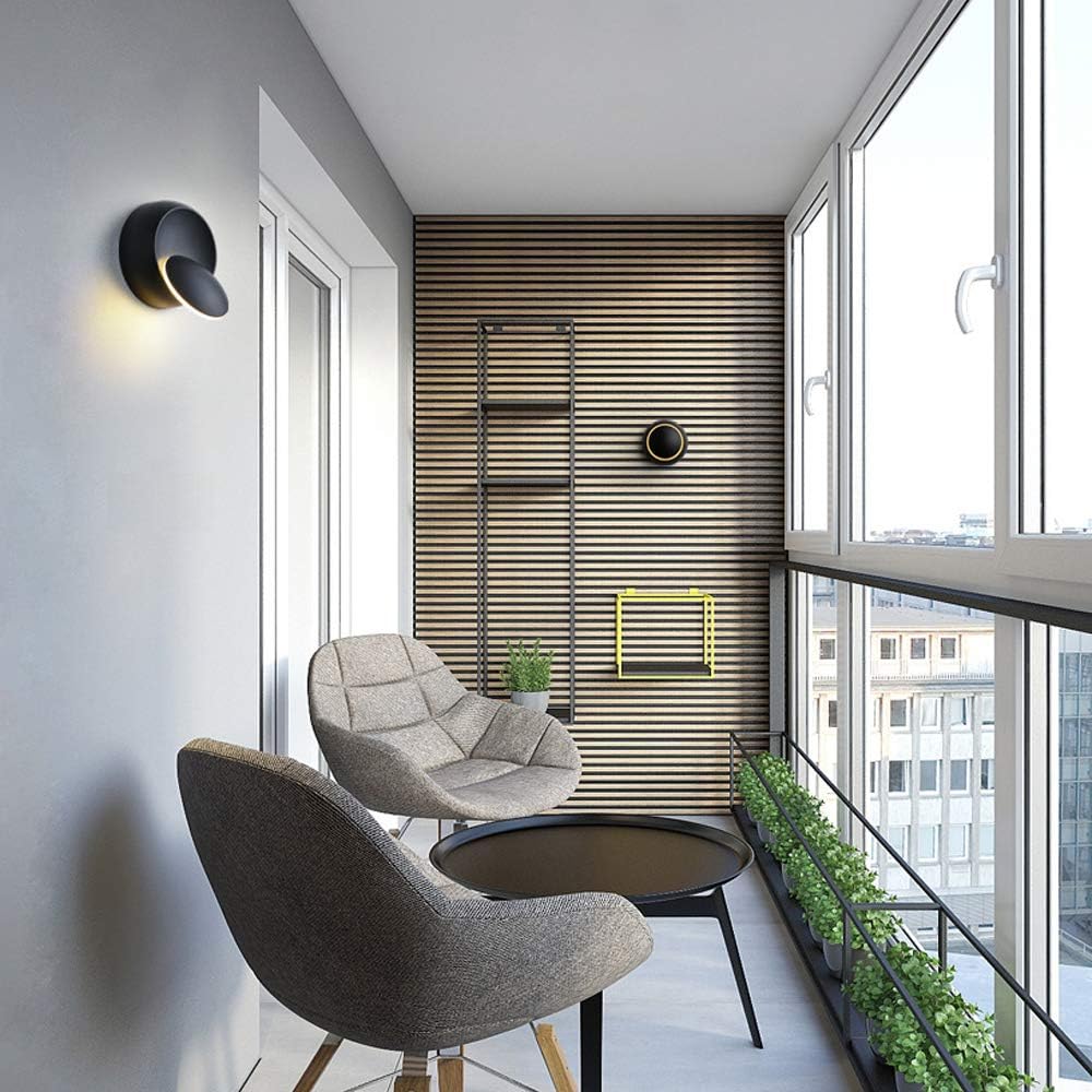 Modern balcony with two chairs, a small table, and a view of city buildings.