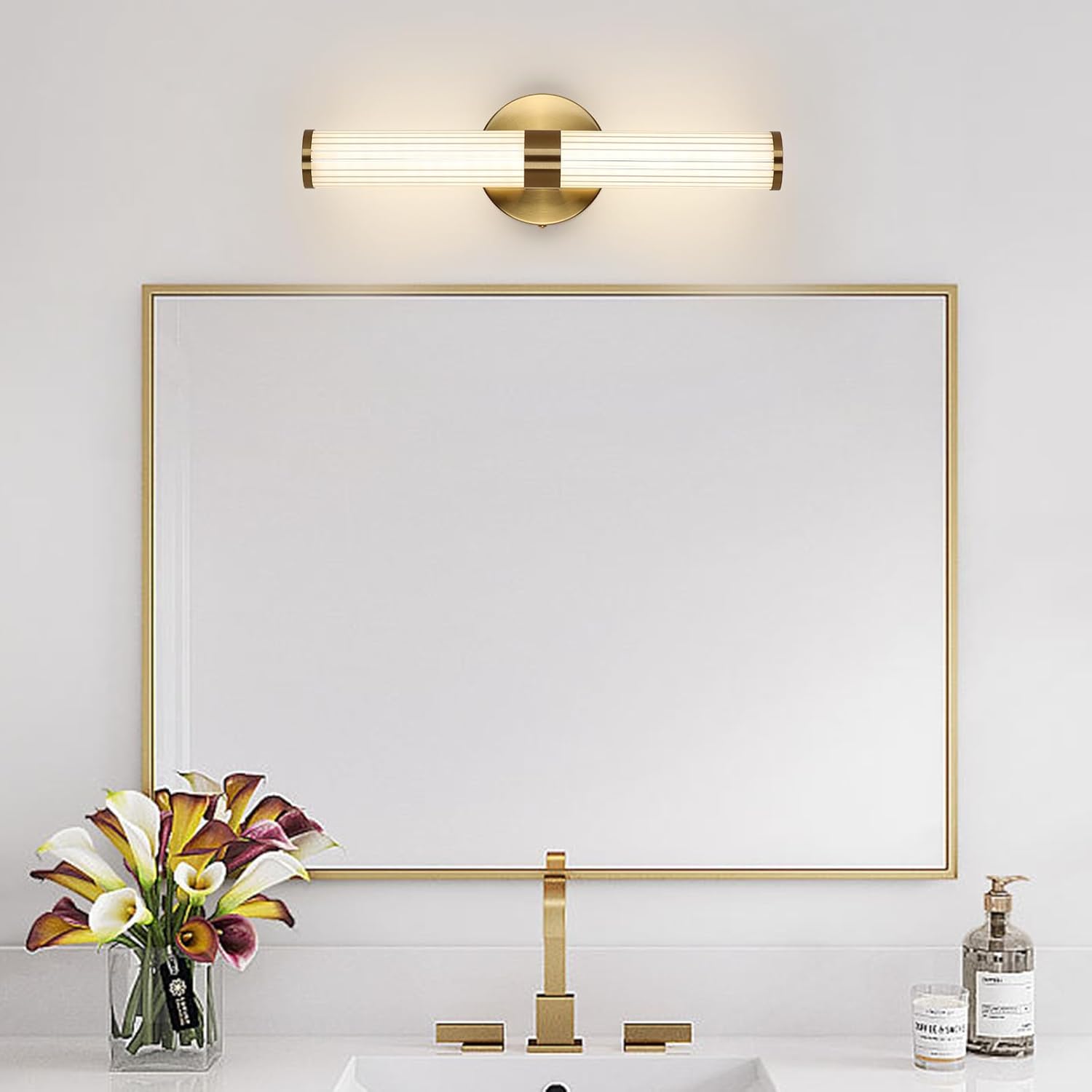 Modern bathroom setup with a gold-framed mirror, sink, and decorative elements.