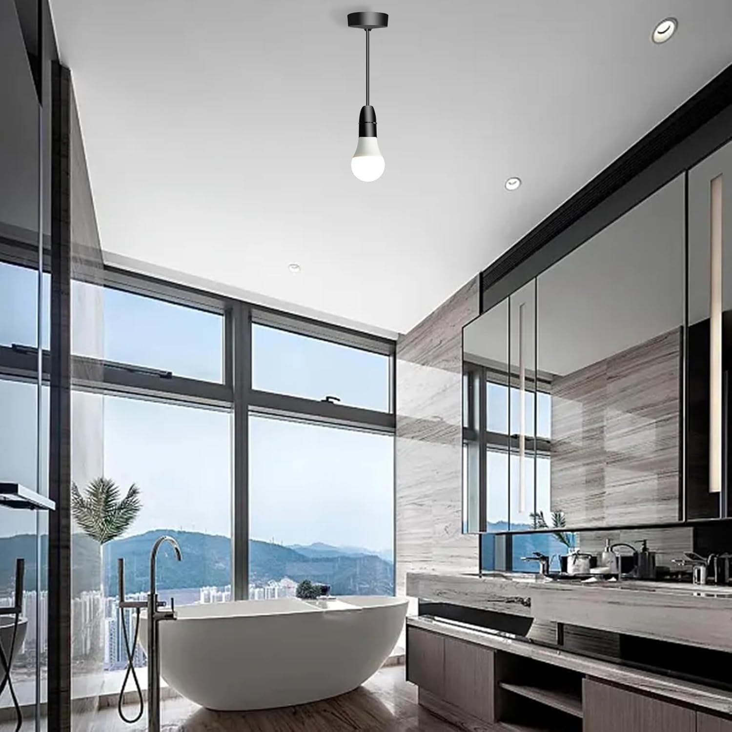 Modern bathroom with a freestanding bathtub, large mirror, and mountain view.