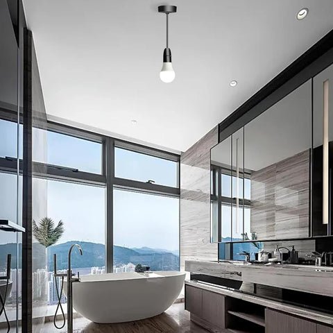 Modern bathroom with a freestanding bathtub, large mirror, and mountain view.