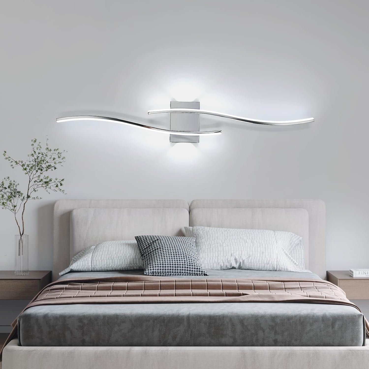 Modern bedroom with a bed, decorative pillows, and a wall-mounted light fixture.