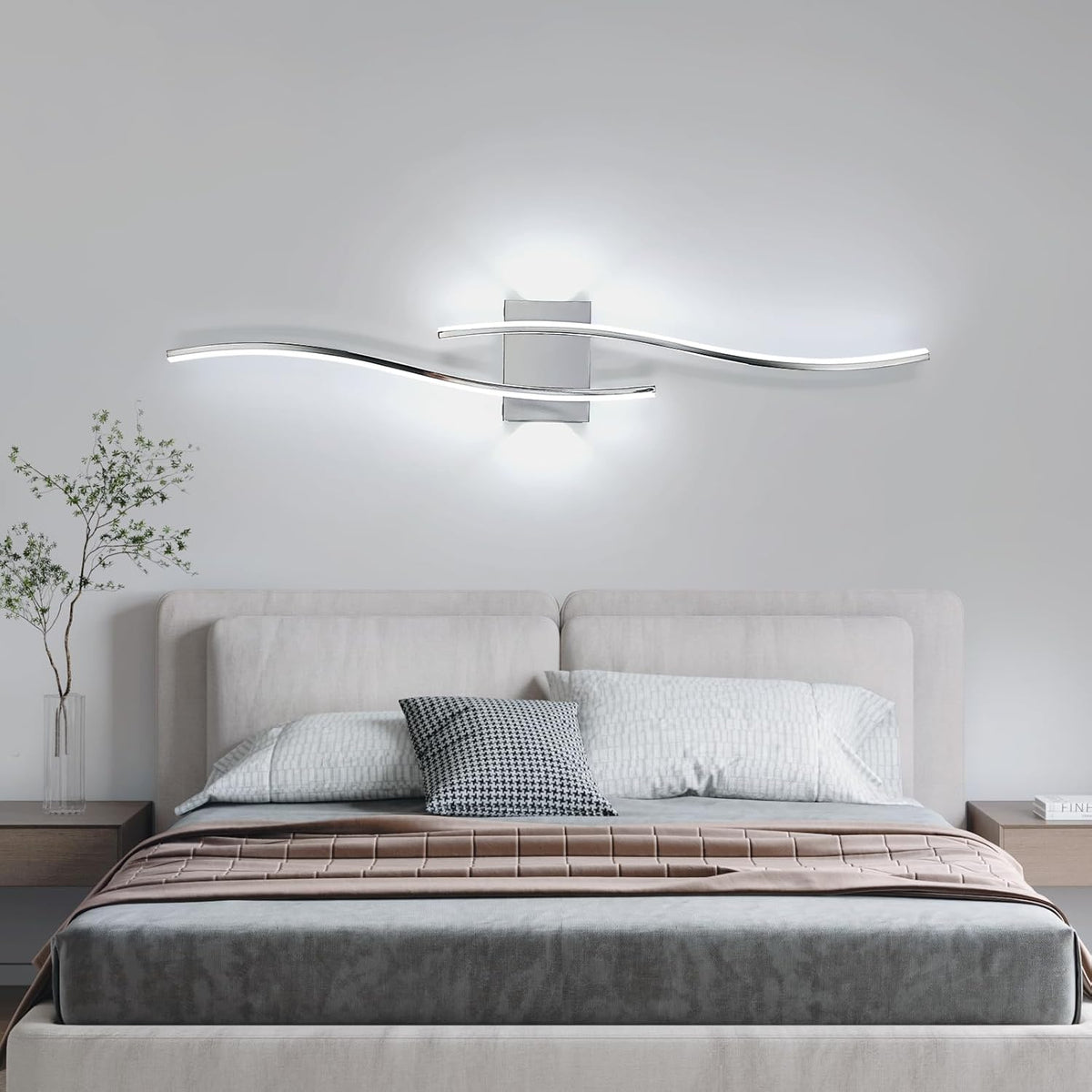 Modern bedroom with a bed, decorative pillows, and a wall-mounted light fixture.