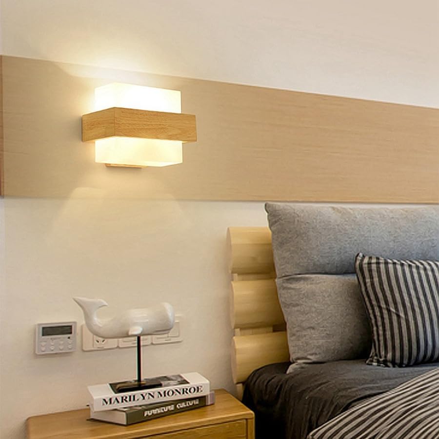 Modern bedroom with a bed, nightstand, and wall-mounted light fixture.