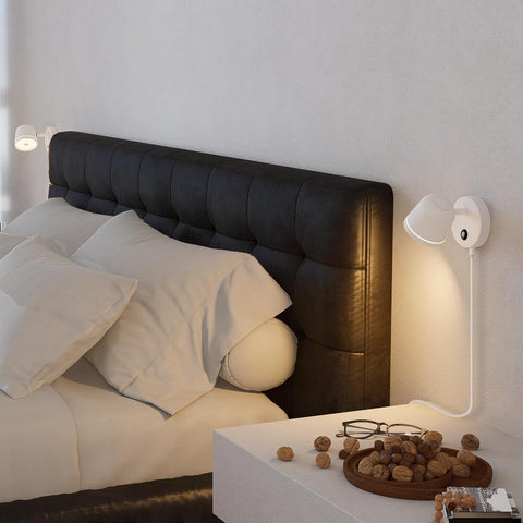 Modern bedroom with a black upholstered headboard and white bedding.