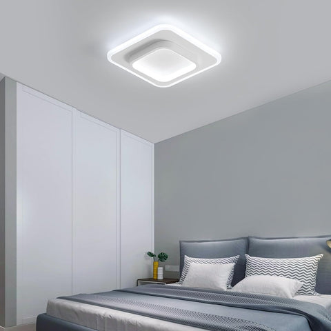 Modern bedroom with a ceiling light fixture, bed, and side table.