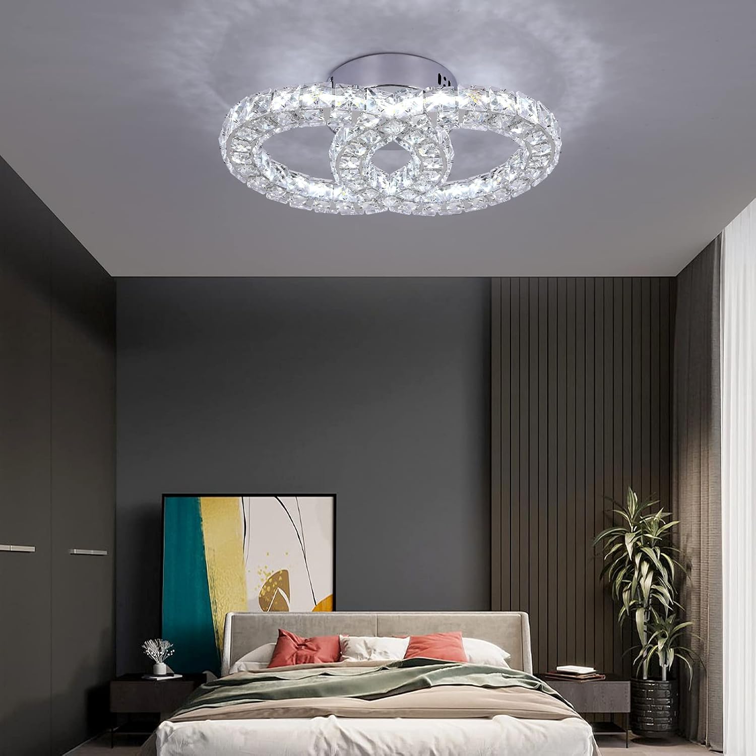 Modern bedroom with a crystal ceiling light fixture, bed, and decor.