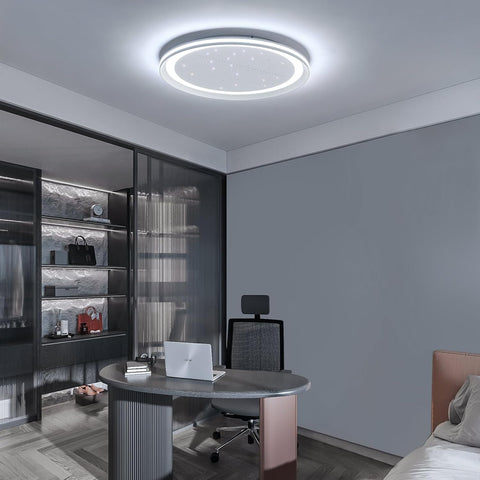 Modern bedroom with a round ceiling light fixture, desk, and bed.