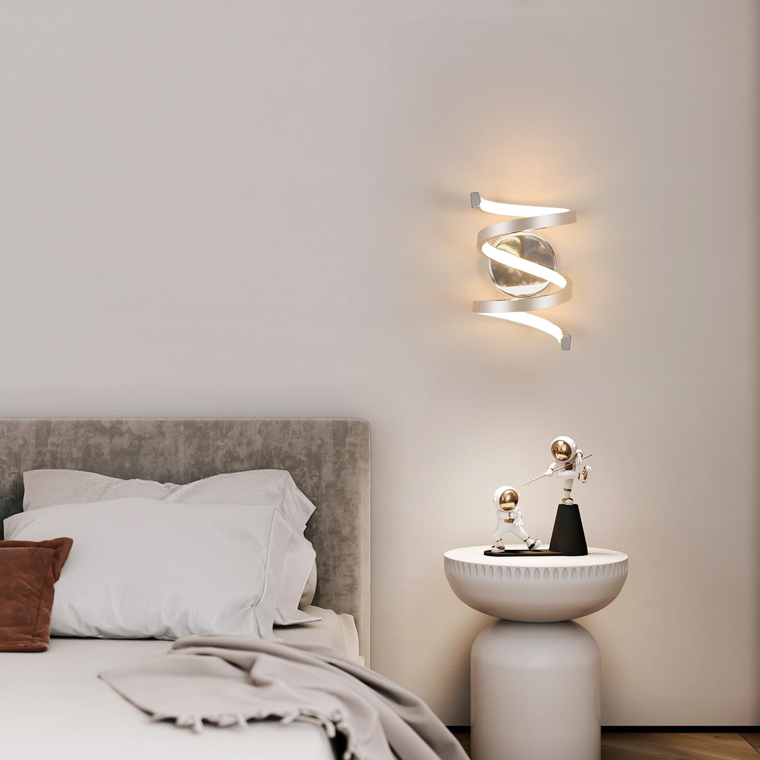 Modern bedroom with a spiral wall light fixture and decorative items on a nightstand.