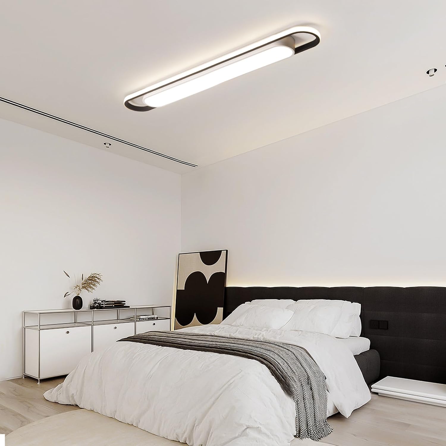 Modern bedroom with a ceiling light fixture, bed, and side table.