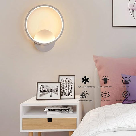 Modern bedroom with wall-mounted light fixture, nightstand, and bed.
