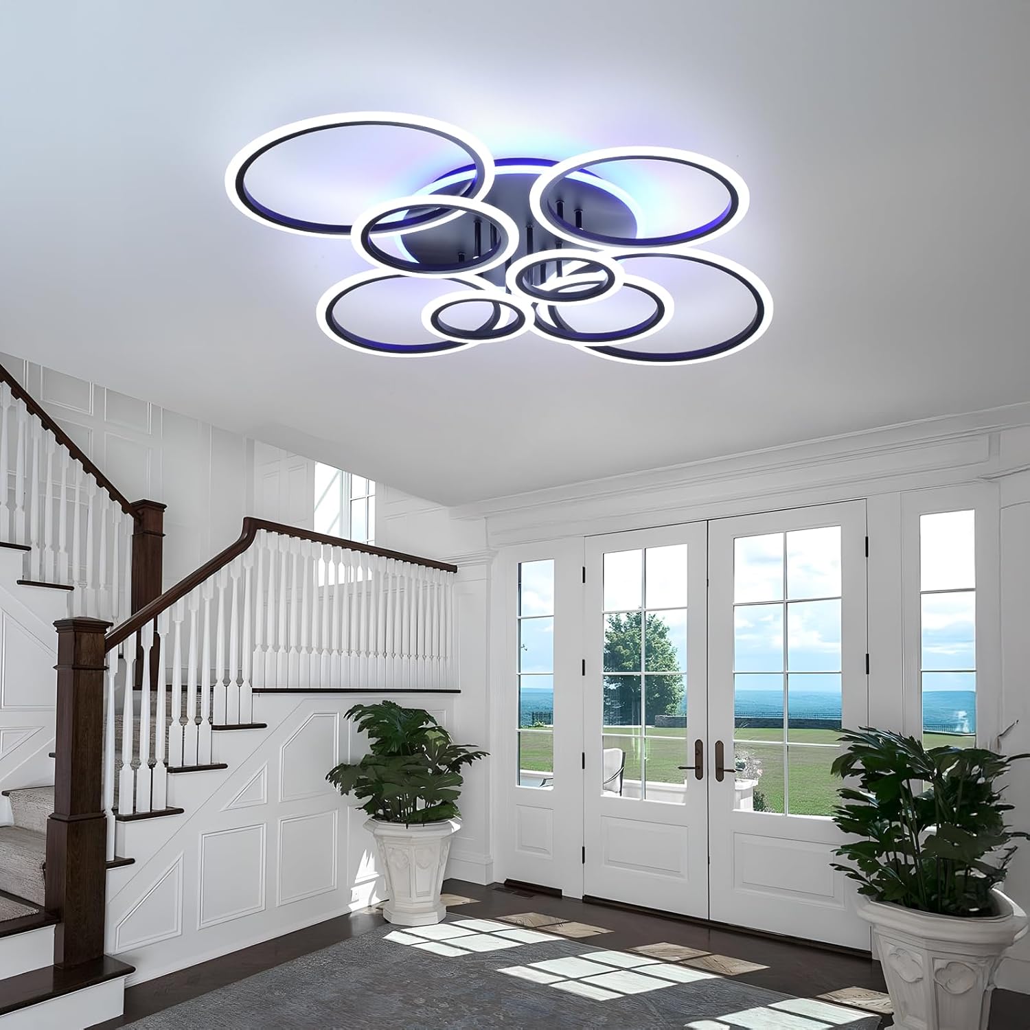 Modern ceiling light fixture in a home interior with staircase and glass doors.