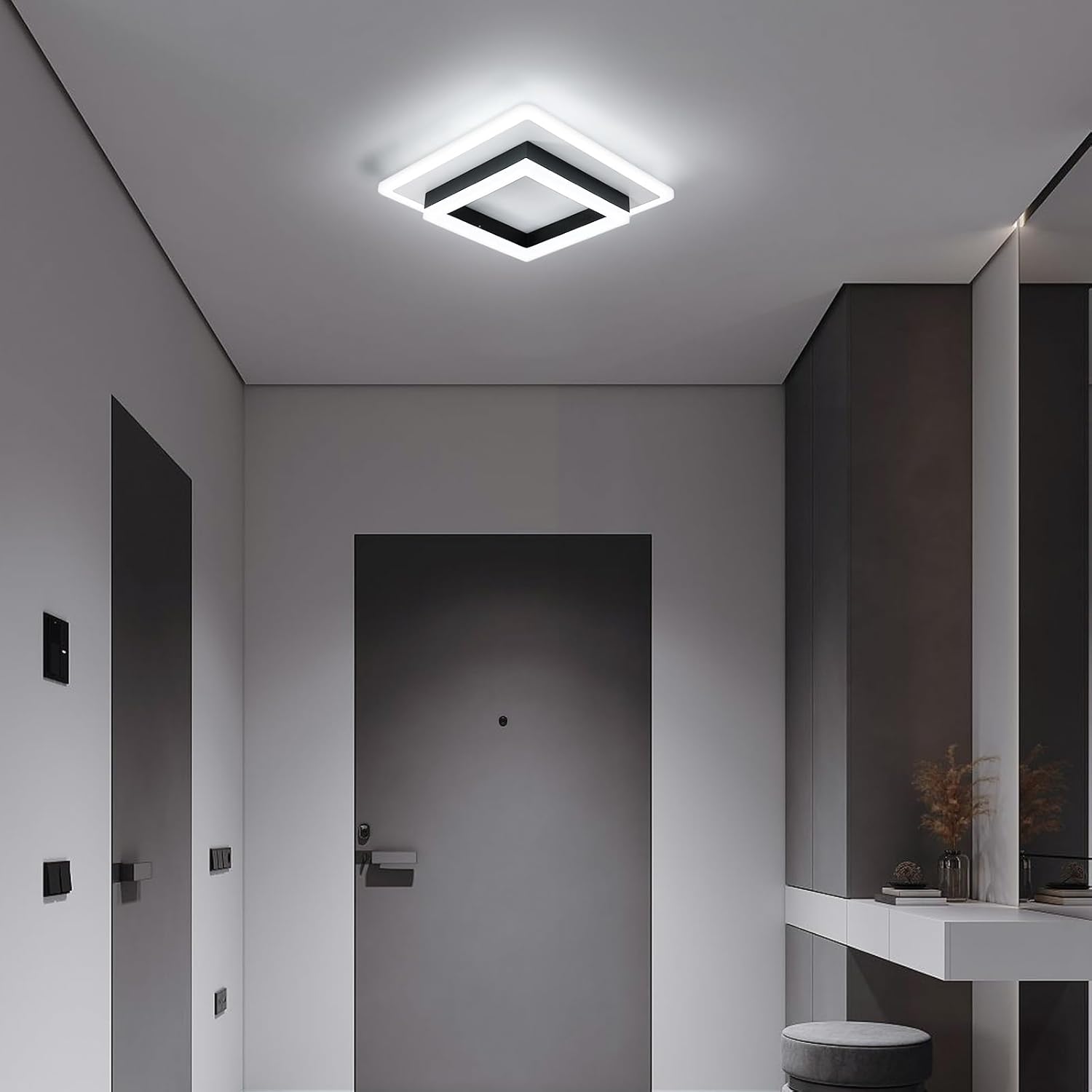 Modern ceiling light fixture in a minimalistic room with gray walls and a white ceiling.