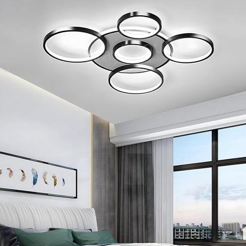 Modern ceiling light fixture in a room with a window and decor.