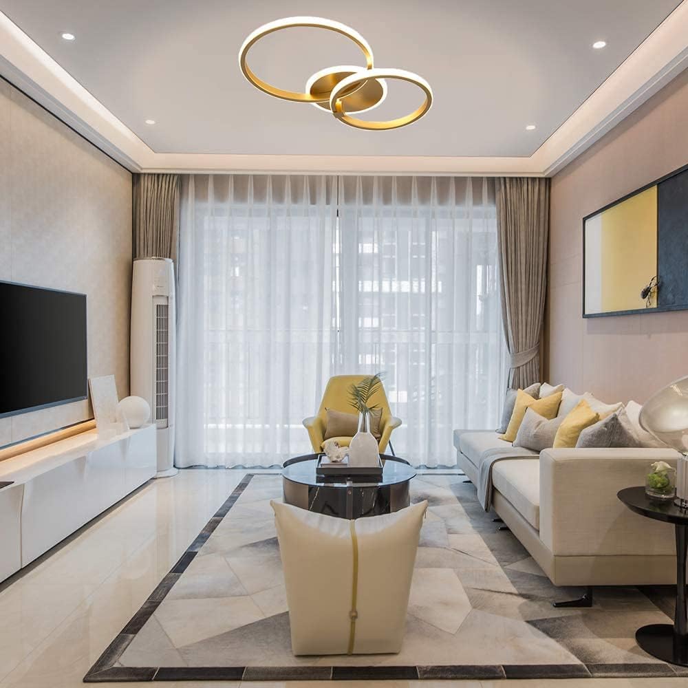 Modern ceiling light fixture with gold and white rings on a neutral background