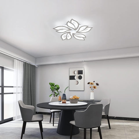 Modern dining room with a round table and chairs, decorative wall art, and ceiling light fixture.