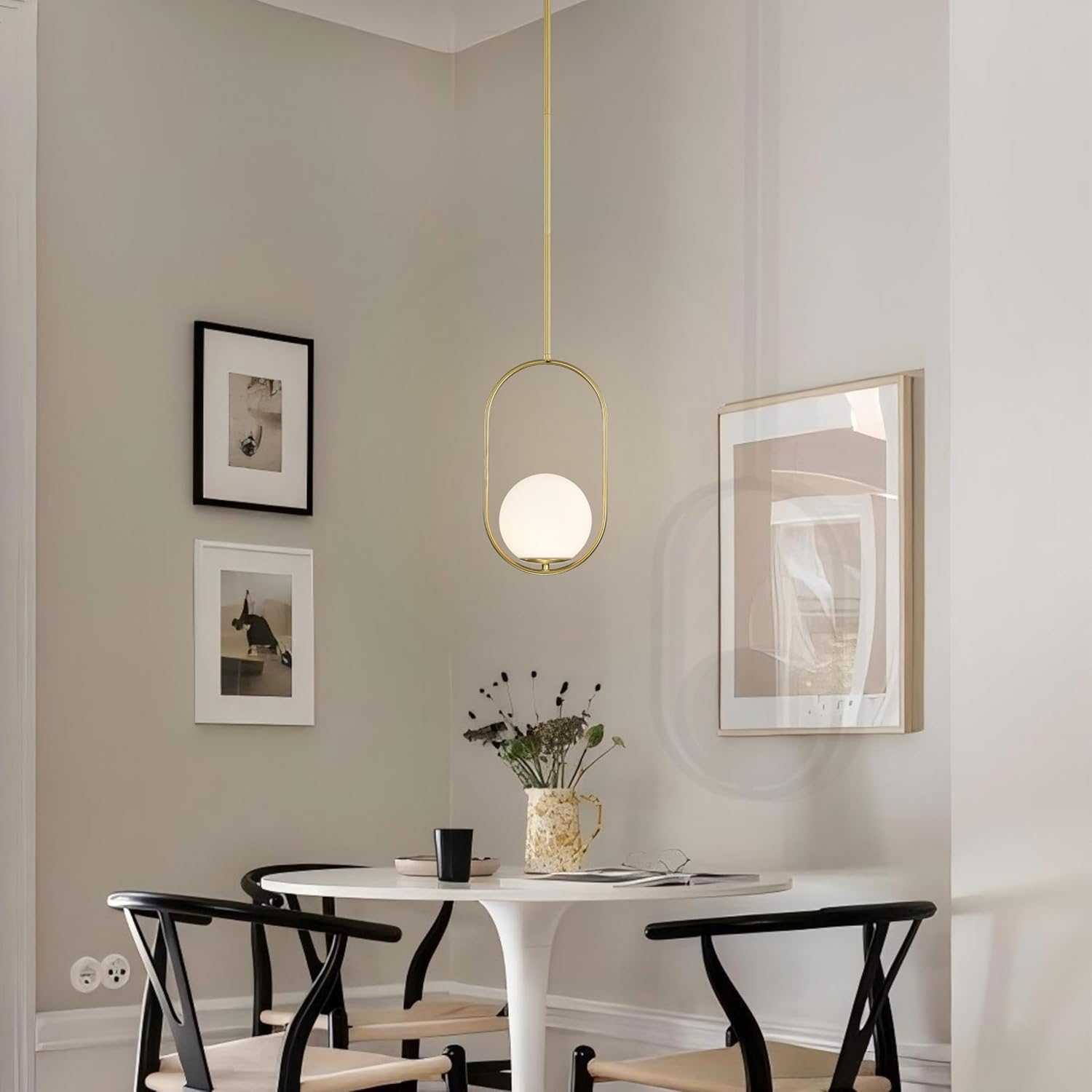 Modern dining room with a white table, black chairs, and a pendant light.