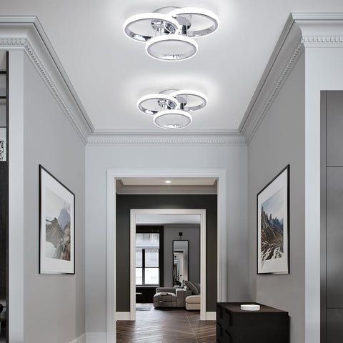 Modern hallway with ceiling lights and framed pictures on a gray wall.