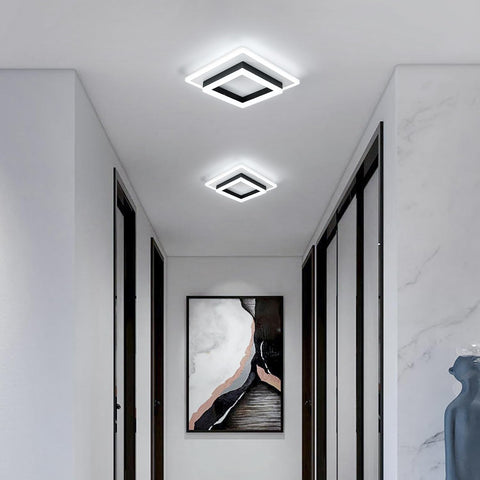 Modern hallway with square ceiling lights, marble wall, and abstract art.
